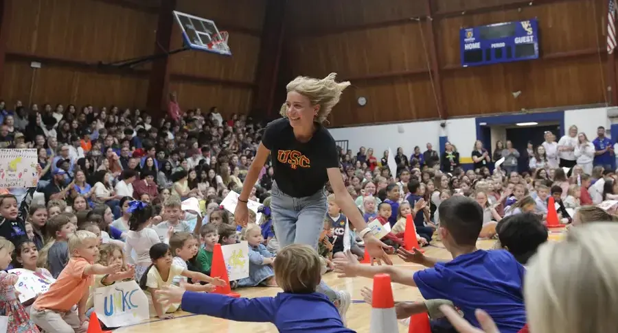 Senior students run down the aisle and high-fives younger students during Senior Sendoff celebration