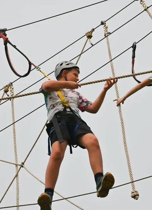Middle school student traversing high-ropes course