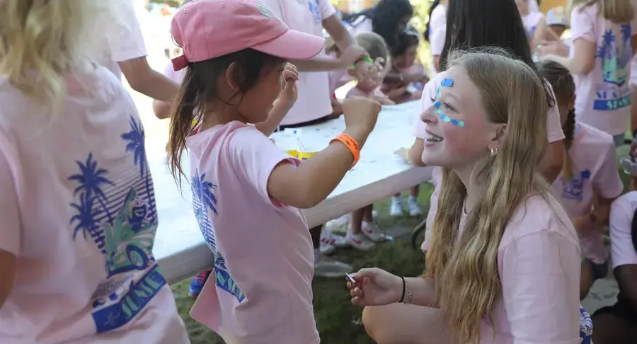Early childhood and middle school students get their faces painted during Picnic Buddy Day