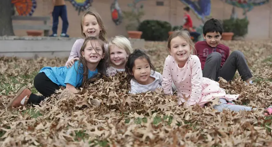Students sat in leaf pile
