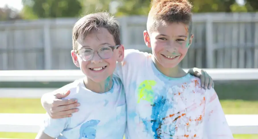 Students covered in paint and smiling together