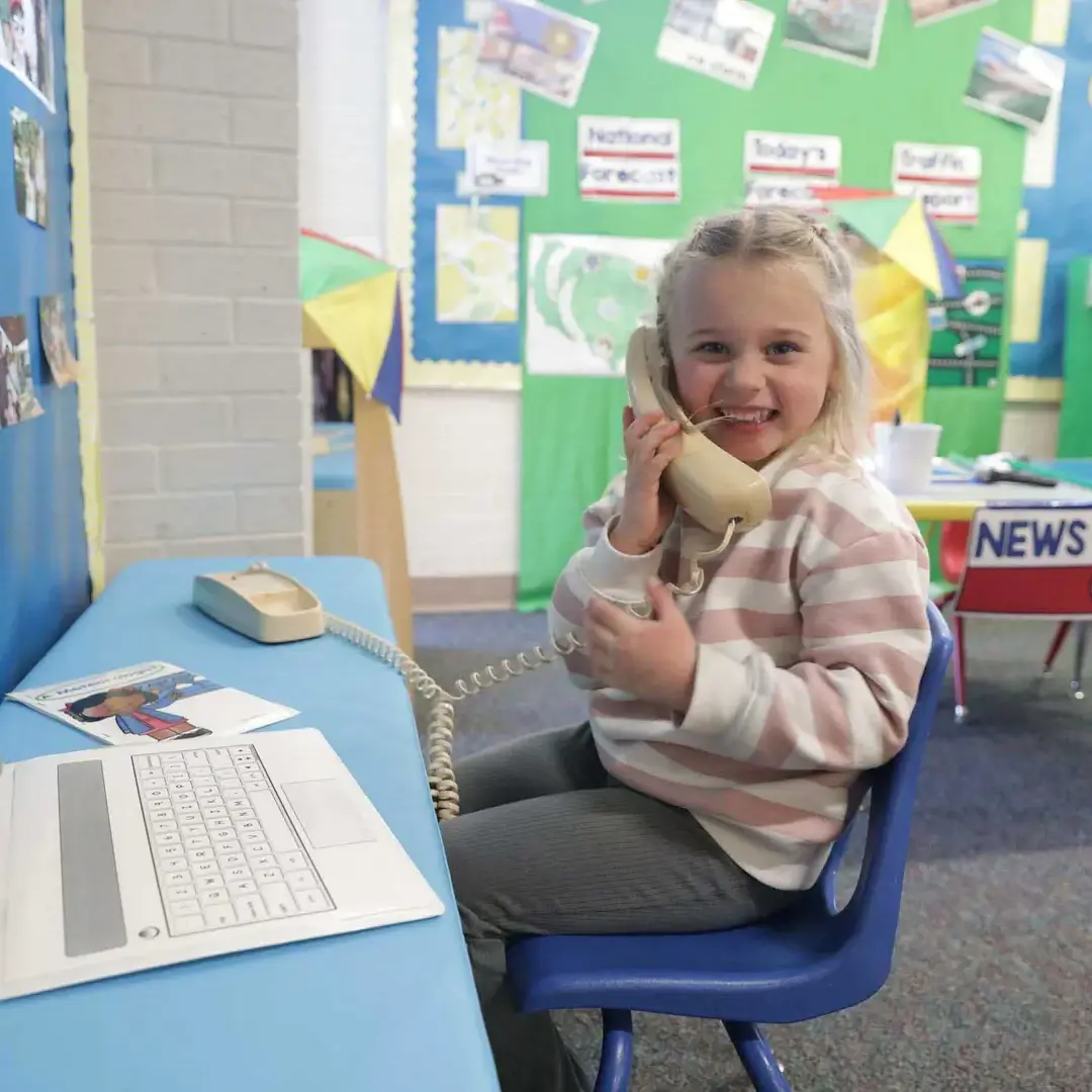 Student using playphone in class and smiling